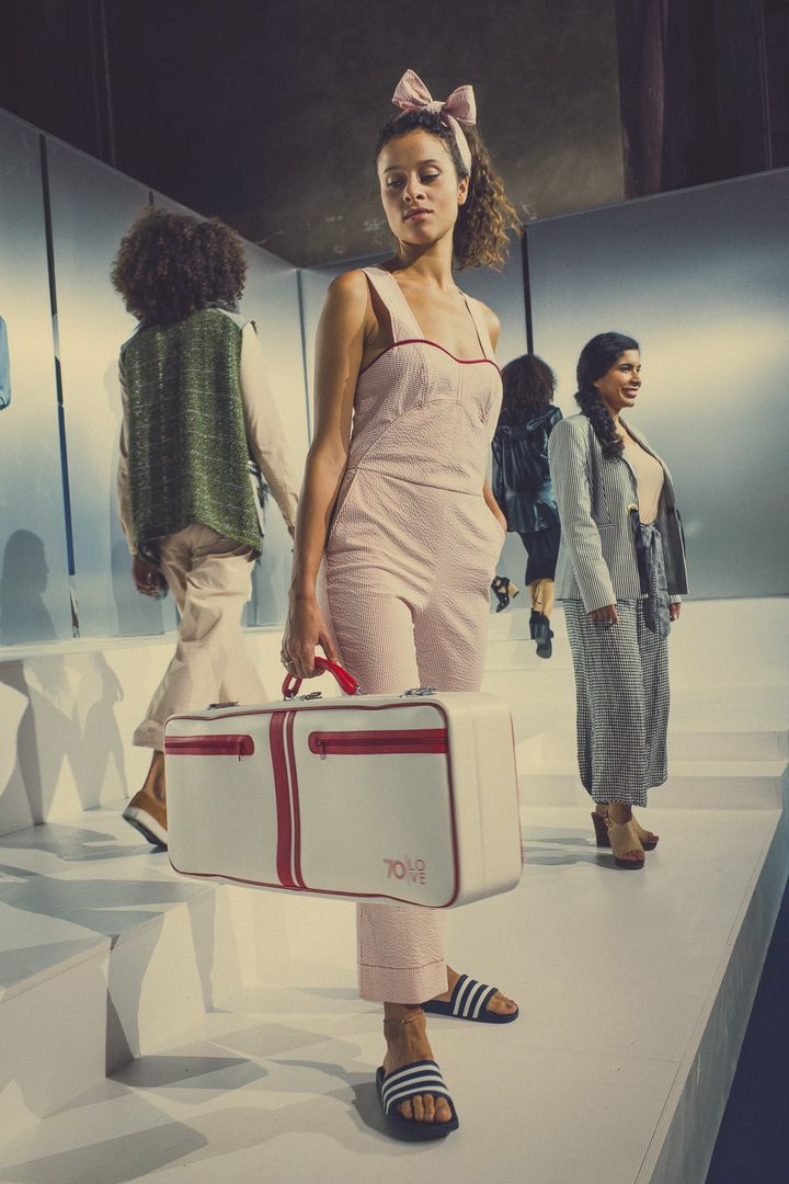 Model auf dem Laufsteg der Fashion Week mit dem roten Tenniskoffer Jim
